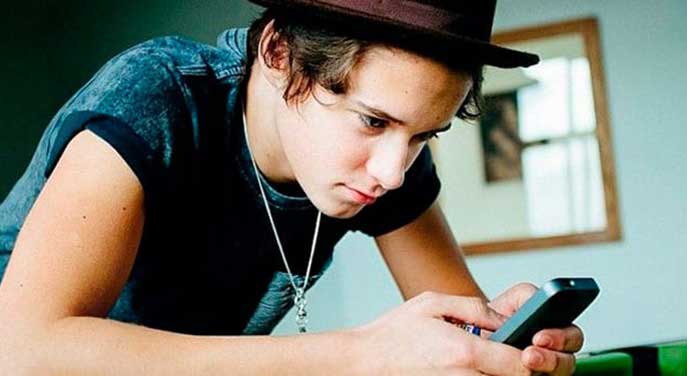 Young man on a cell phone Equipping young people to better manage their financial futures